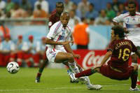 Ht moment van de ontmoeting tussen Frankrijk en Portugal. Henry valt over het uitgestoken been van Carvalho (r).