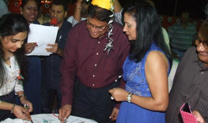 Terwijl er gezongen wordt, snijdt Chandrikapersad Santokhi de taart aan. De VHP-voorzitter wordt maandag 55 jaar en vierde dat zaterdag in Nickerie.    