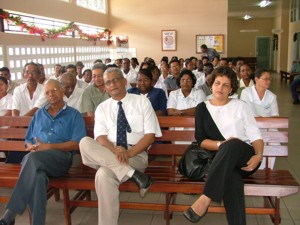 Foto: Minister Rakieb Khodabux van Volksgezondheid luistert samen met anderen naar de toespraken tijdens zijn werkbezoek aan het SZN.