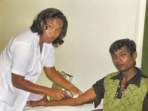 Een medewerkster van de bloedbank neemt in het SZN bij een nieuwe donor bloed af voor verder onderzoek.-.
