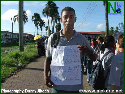 Een student toont zijn protest tekst "Geen stroom geen school" aan DBS 