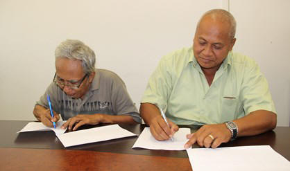 Kardi Kartosowieto van de SNRI (l) en Carlo Soemotinojo van de SML plaatsen hun handtekeningen onder het samenwerkingsdocument.